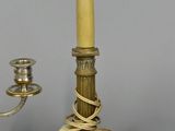 three brass candlesticks and a candle holder on a table