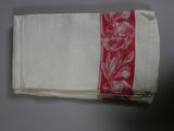two red and white napkins on a table with a red stripe