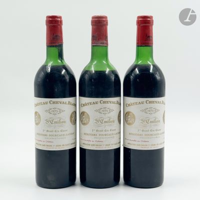 trois bouteilles de vin rouge posées l'une à côté de l'autre sur une surface blanche