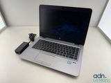 a laptop computer sitting on a desk with a charger