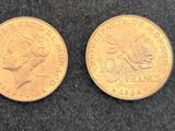 two gold coins, one of which has a woman ' s head and one of which is a man ' s head