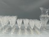a lot of wine glasses and a pitcher on the table