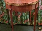 a small table with a wooden top on a green carpeted floor