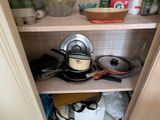 un placard de cuisine sur lequel sont posés des casseroles et des poêles