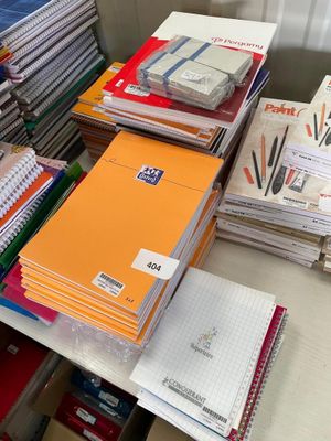 une pile de livres et de cahiers posée sur un bureau