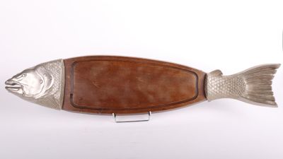 une planche à découper en bois en forme de poisson posée sur une surface blanche