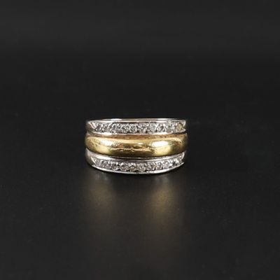 une bague en or et en argent sertie de diamants sur un fond noir