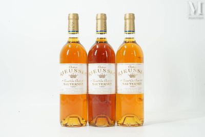 three bottles of wine sitting next to each other on a white surface
