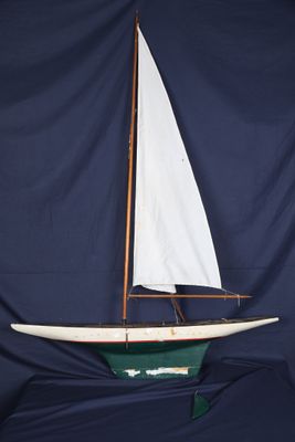 une maquette de voilier avec une voile blanche