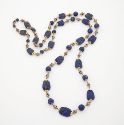 un collier composé de perles de lapis-lazuli et d'or sur fond blanc