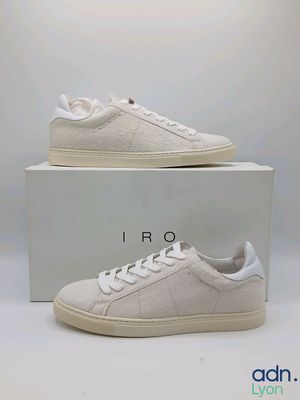 une paire de baskets blanches posée sur une boîte