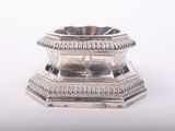 a silver candle holder on a white surface