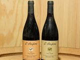 deux bouteilles de vin posées l'une à côté de l'autre sur un tonneau