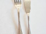 deux fourchettes et une cuillère sur une table blanche