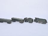four toy trains that are sitting on a white surface