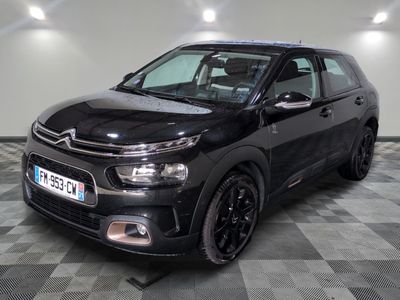 La Citroën noire est garée dans le garage, sur un sol à damier.