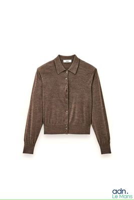 a close up of a sweater on a hanger on a wall