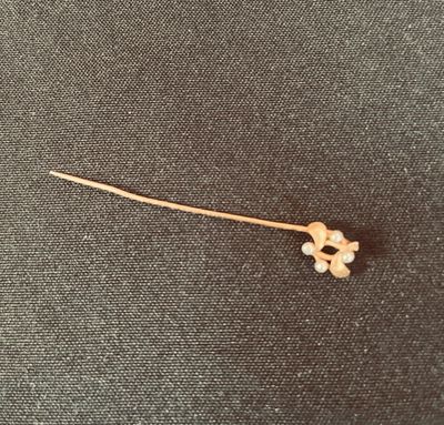 une petite fleur blanche sur une tige posée sur un tissu noir