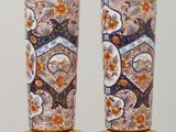 pair of vases sitting on top of a wooden table next to each other