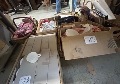 plusieurs cartons remplis d'objets dans un garage, avec un homme debout à côté