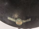 a large black bell with a green sticker on it