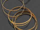 un lot de cinq bracelets en or posés sur un fond noir