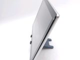 a tablet computer sitting on a stand on a white surface