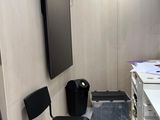 a black chair in the corner of a small room
