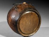 a wooden barrel with a metal handle on a table