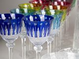 many different colored wine glasses lined up on a table