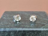 une paire de boucles d'oreilles en diamant posée sur une table en marbre