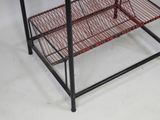 a metal shelf with a red wire basket on it