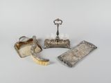 three pieces of silverware including a brush, a tray and a bottle