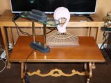 une table sur laquelle se trouvent un ventilateur et un téléviseur