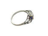 a close up of a diamond and sapphire ring on a white background