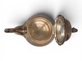 a silver teapot with a lid on a white surface