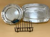 deux plateaux en argent et une grille posés sur une table