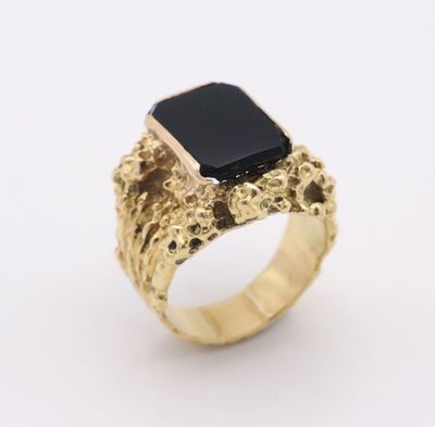 a gold ring with a black stone in the center