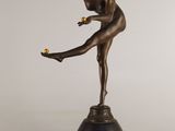 bronze statue of a woman holding a tennis racquet on top of a pedestal