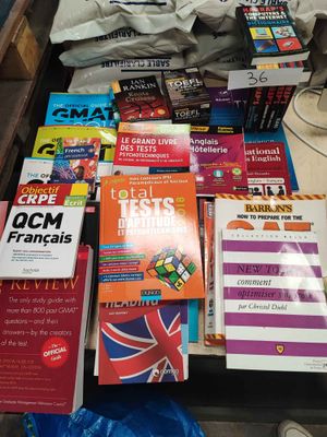 beaucoup de livres posés sur une table, avec une lampe