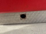 a close up of a red truck with a hole in the side
