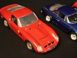 three toy cars sitting side by side on a black surface