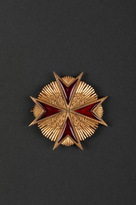 a close up of a red and gold star on a black surface