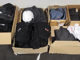de nombreux cartons de vêtements qui traînent par terre
