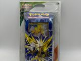un gros plan sur une boîte de cartes Pokémon posée sur une surface blanche