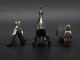 three silver figurines that are sitting on a table