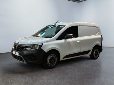 La camionnette blanche est garée dans une pièce au sol noir.