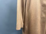 Ce manteau est en laine et comporte des boutons dans le dos.