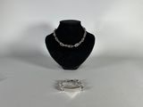 two pieces of jewelry sitting on top of a table next to each other
