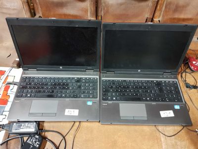 two open laptop computers sitting on top of a table next to each other